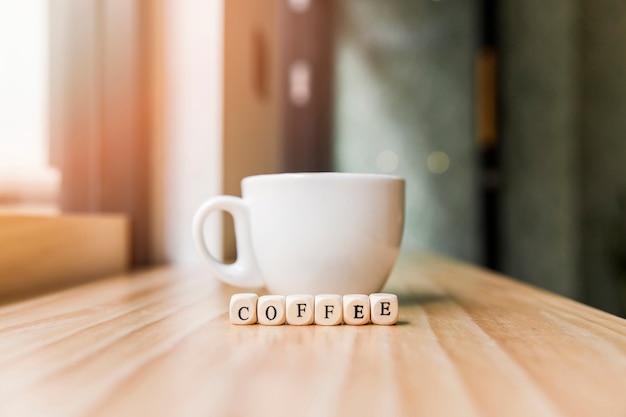 木製の表面にコーヒーのカップとコーヒー単語
