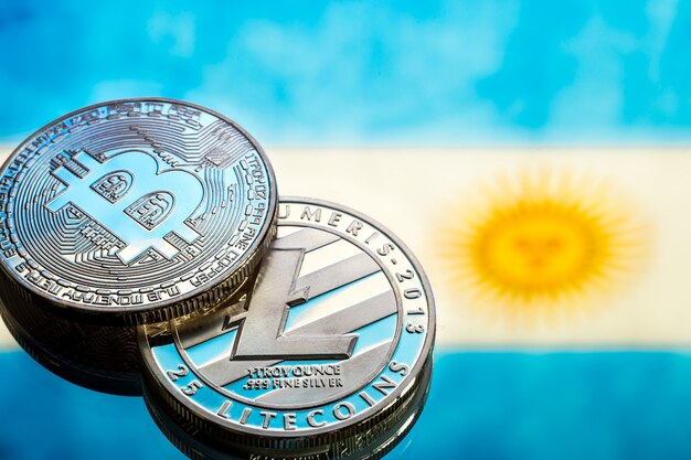 coins Bitcoin and litecoin, against the background of Argentina flag, concept of virtual money, close-up. Conceptual image.