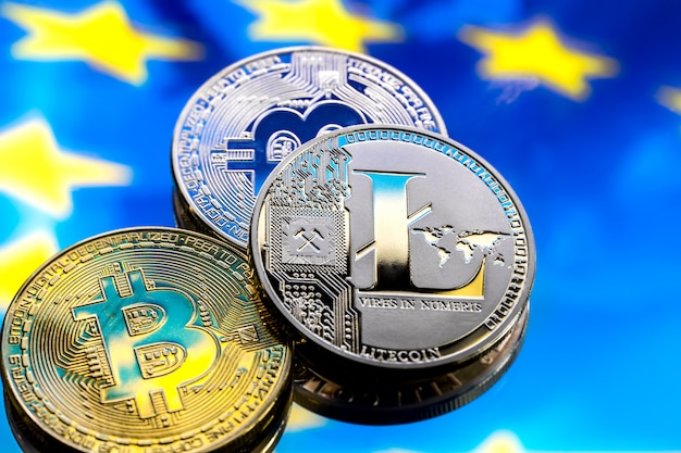 コインビットコインとライトコイン、ヨーロッパとヨーロッパの旗を背景に、仮想マネーのコンセプト、クローズアップ。