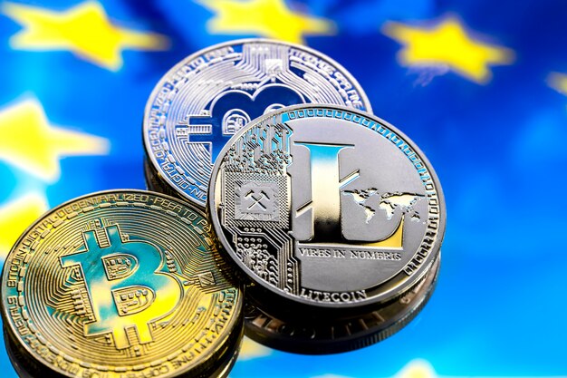 コインビットコインとライトコイン、ヨーロッパとヨーロッパの旗を背景に、仮想マネーのコンセプト、クローズアップ。