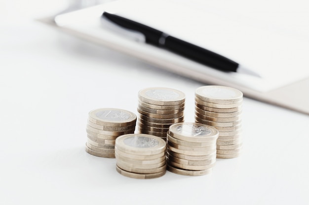 Coins and pen on wooden table