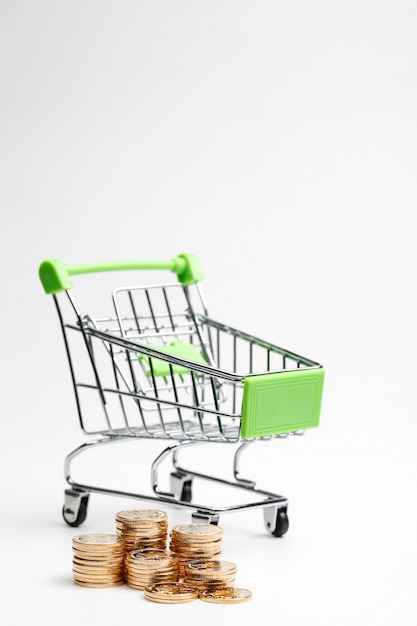 COINS pile and shopping cart on a white background