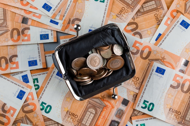 Free photo coins in purse on banknote and plaster table .