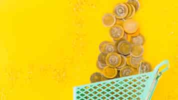 Бесплатное фото Монеты, разбросанные из продуктовой тележки