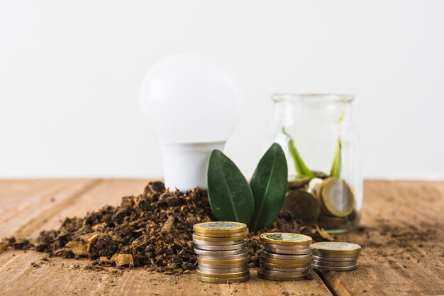 Coins stack with light bulb and jar 