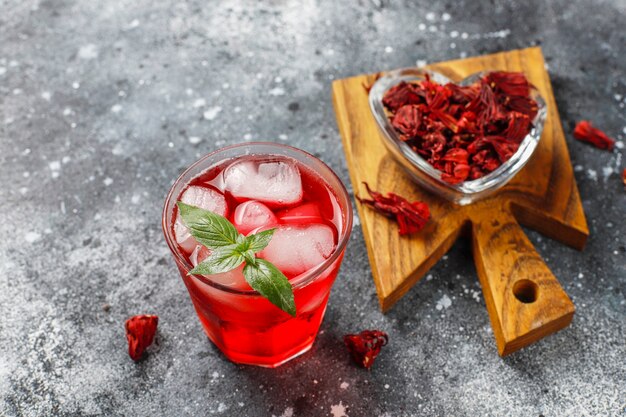 Cold brew hibiscus tea with ice and basil leaves.