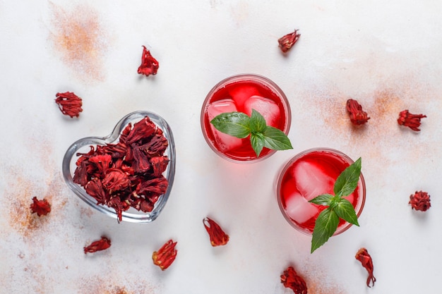 Cold brew hibiscus tea with ice and basil leaves.