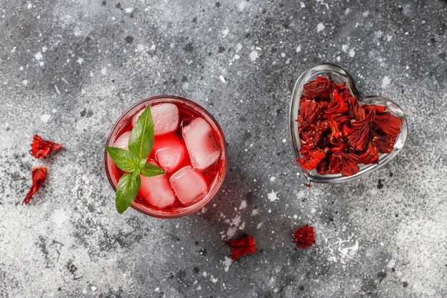 Tè freddo all'ibisco con ghiaccio e foglie di basilico.