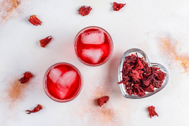 Tè freddo all'ibisco con ghiaccio e foglie di basilico.