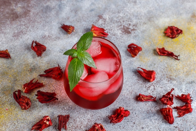 Free photo cold brew hibiscus tea with ice and basil leaves.