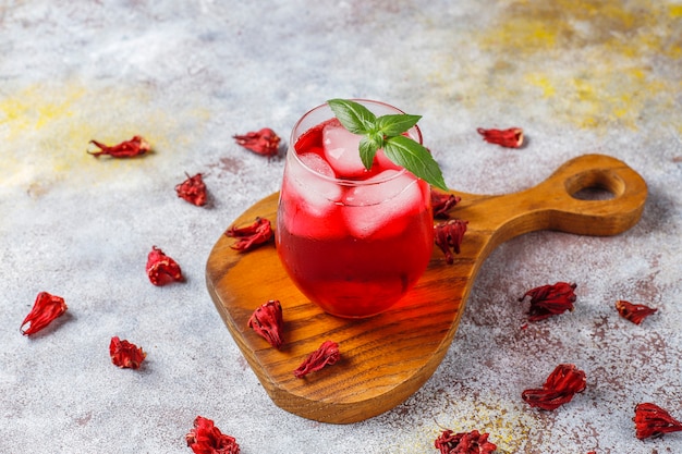 Free photo cold brew hibiscus tea with ice and basil leaves.