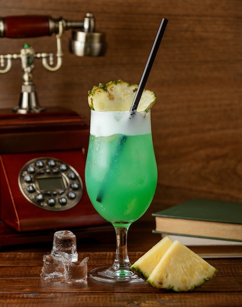 Холодный зеленый коктейль с ломтиком ананаса