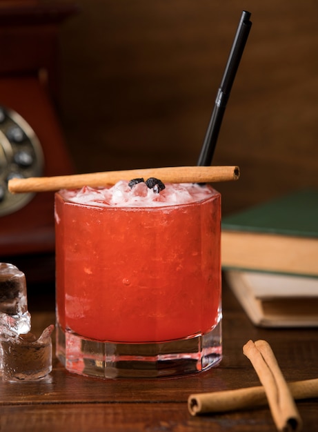 Free photo cold red cocktail with cinnamon sticks