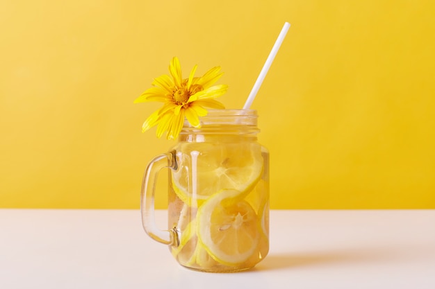 Cold summer thirst quencher with lemon slices and straw