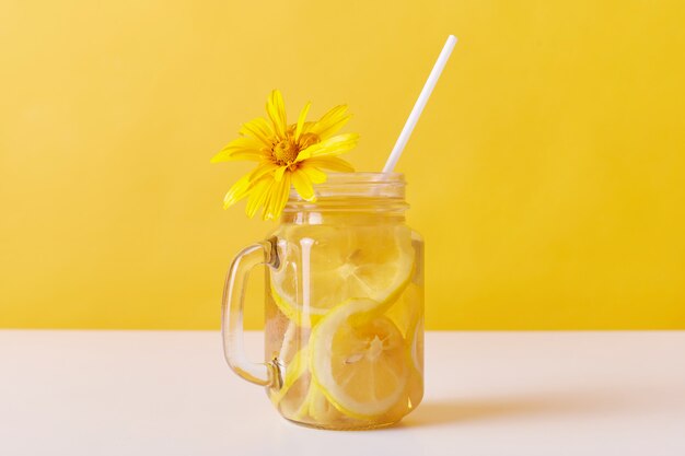 Cold summer thirst quencher with lemon slices and straw