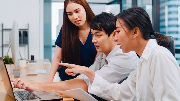 Collaborative process of multicultural businesspeople using laptop presentation and communication meeting brainstorming ideas about project colleagues working plan success strategy in modern office.