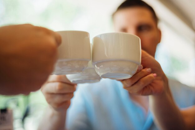 Colleagues clanging cups with hot drinks together