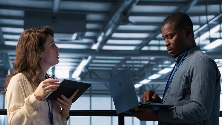 Free Photo colleagues in data center workplace use laptop to calibrate energy usage