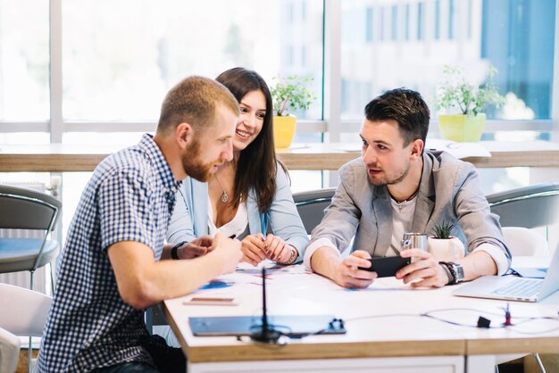 Colleagues discussing plans on smartphone