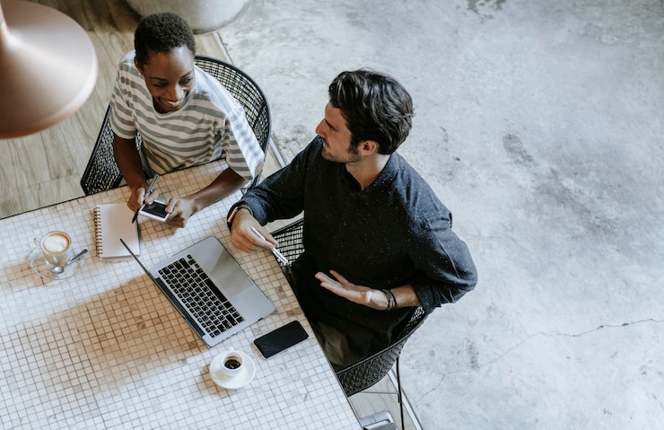 Free Photo colleagues discussing their work on a laptop