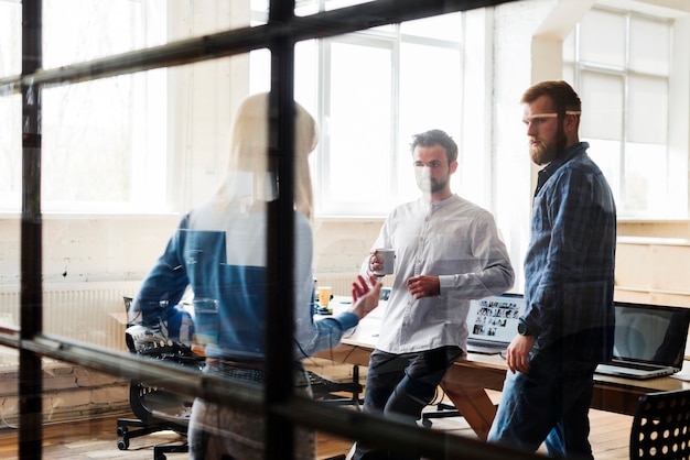 Colleagues discussing with each other in office