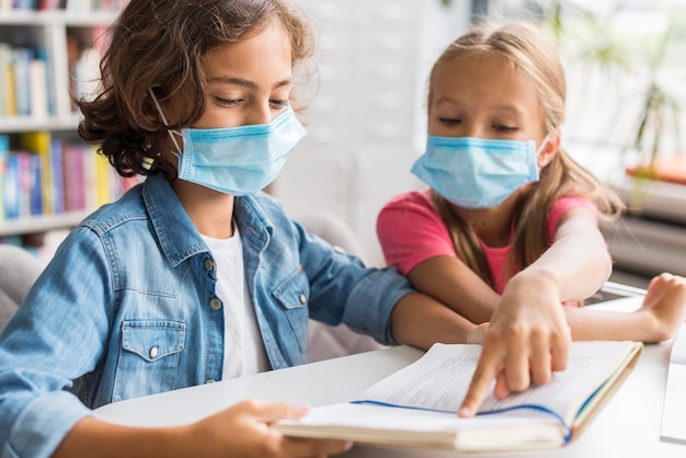 Colleagues doing their homework while wearing a face mask