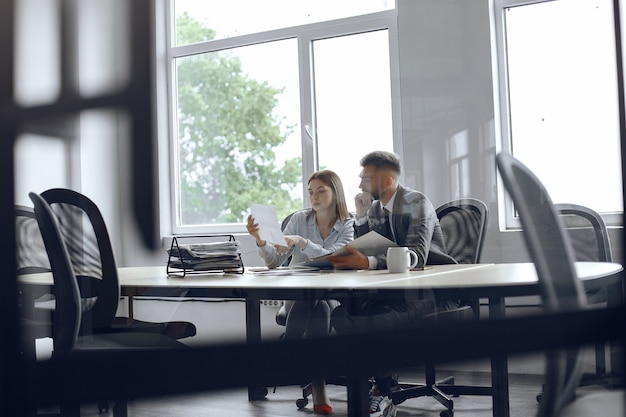 Free photo colleagues drink coffee.business partners at a business meeting.man and woman sitting at the table