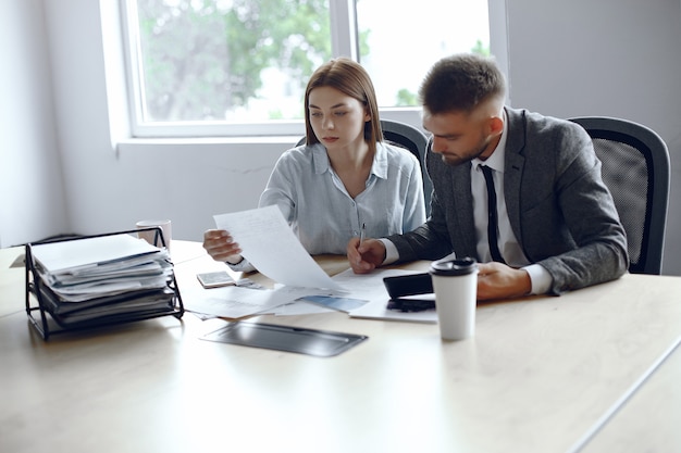 Colleagues drink coffee.Business partners at a business meeting.Man and woman sitting at the table