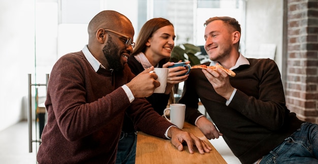 コーヒーを飲みながら会議をしている同僚