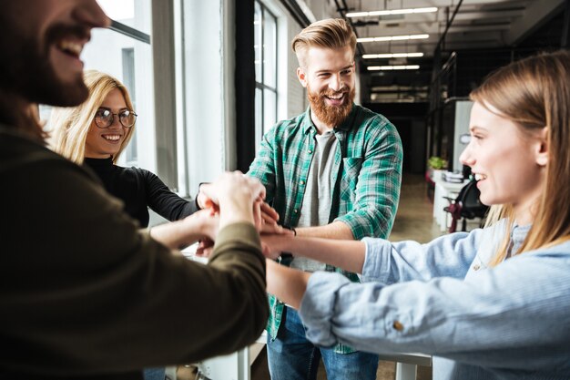 Colleagues in office holding hands of each other