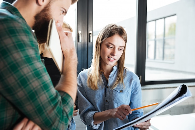 Colleagues in office talking with each other holding folder