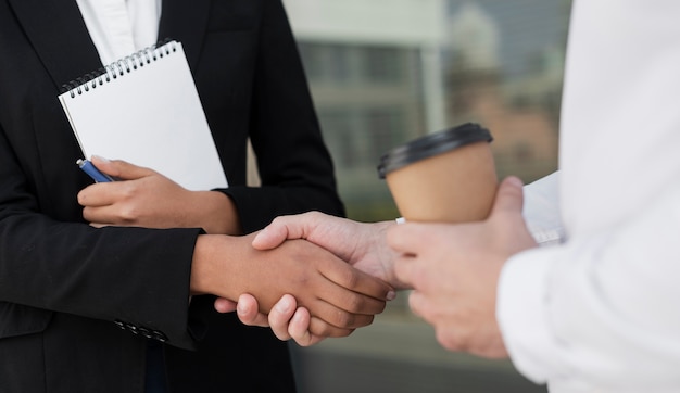 Colleagues shaking hands close up