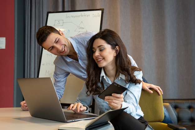 Colleagues smile in office while work