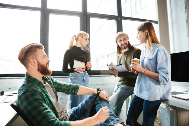 Colleagues standing in office and talking with each other