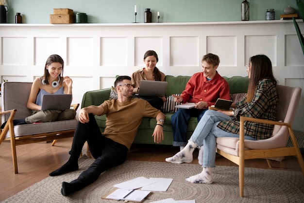 Colleagues using laptops and notebooks for learning in a study session