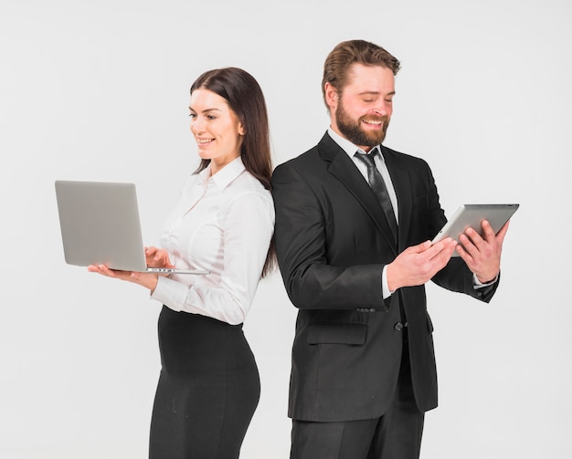 Colleagues woman and man standing with devices 