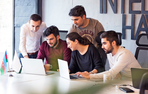 Colleagues working on a project and discussing details. Free Photo