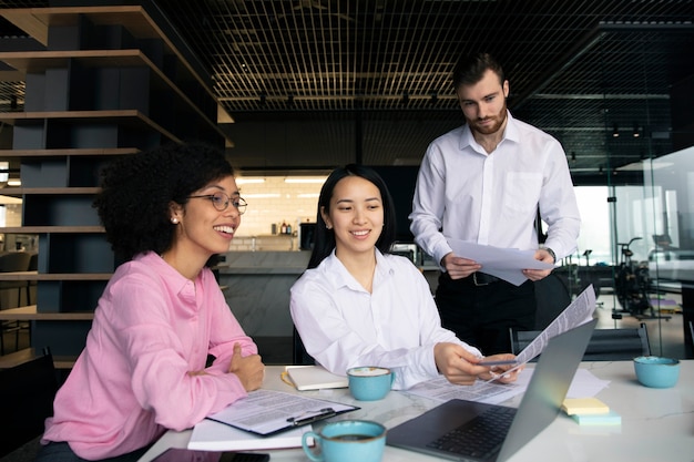 Colleagues working together using a laptop and documents