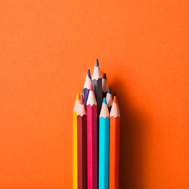 Collection of colored pencils on an orange background