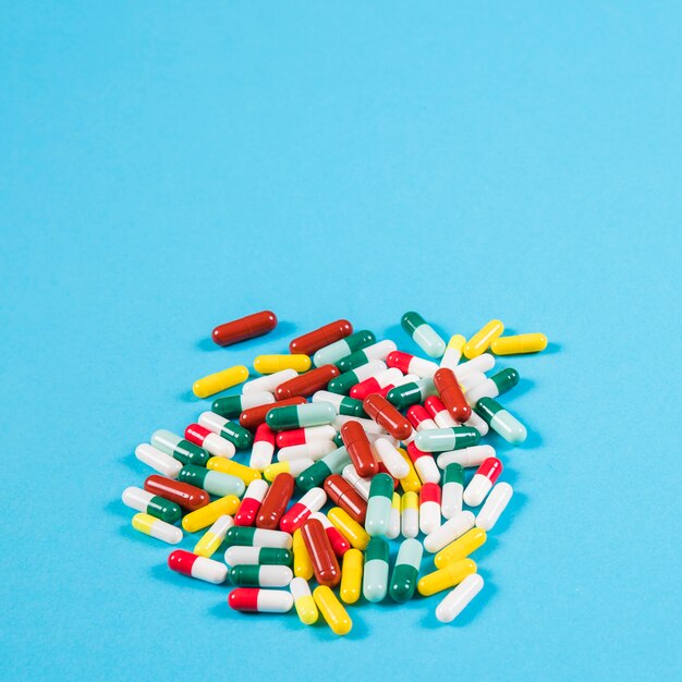 Collection of colorful capsules on blue backdrop