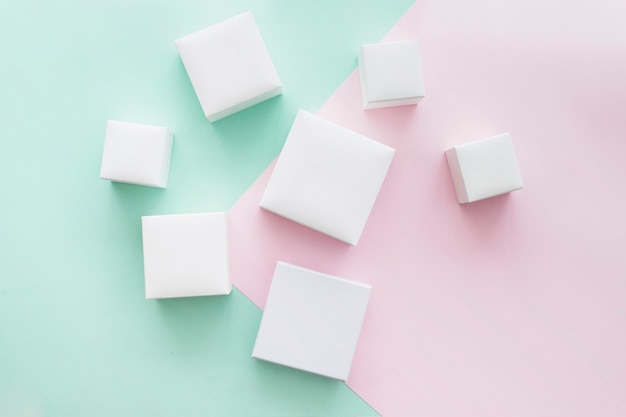 Collection of different white present boxes on pastel backdrop