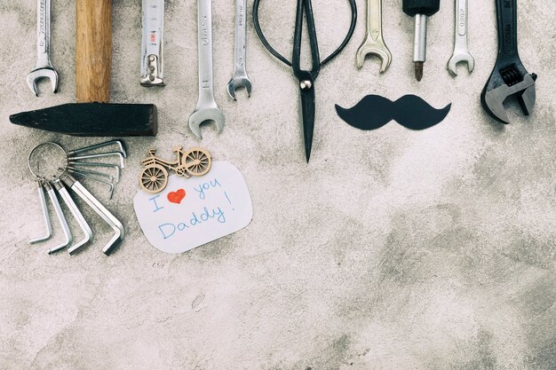 Collection of instruments near decorative moustache with I love you daddy words