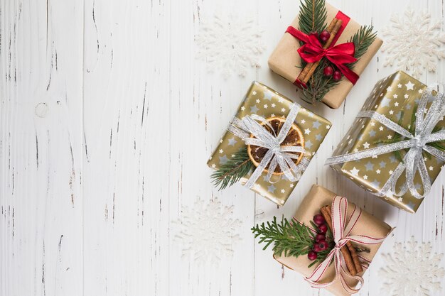 Collection of present boxes in Christmas wrap between ornament snowflakes