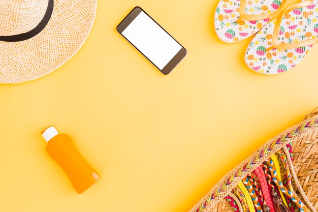 Коллекция тропических пляжных вещей отдыха и телефон на желтом фоне