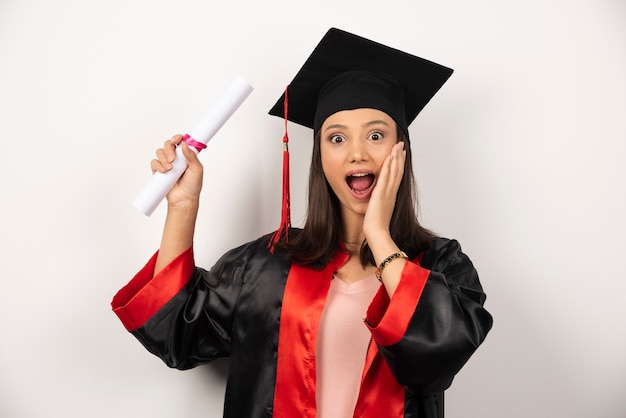 College graduate female in gown feeling happy on white background.