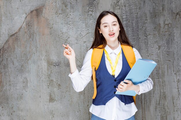 College student in uniform with folder posing. High quality photo