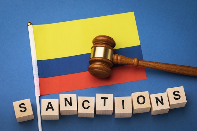 Colombia flag, judge's gavel and wooden cubes with text, concept on the theme of sanctions