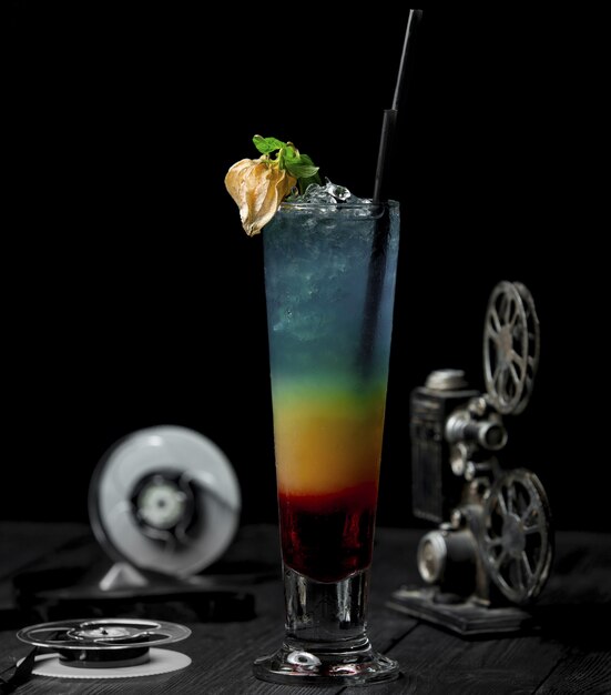 Color alcohol cocktail wiith flower and black pipe.