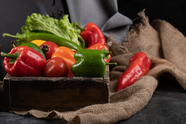 Color peppers and greenery in a rustic tray.