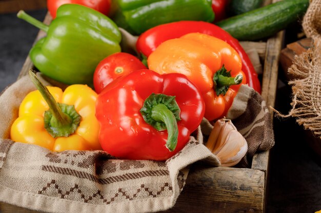 Color peppers in a rustic wooden tray.